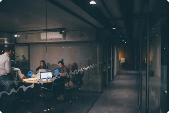 group of team members sitting in their office at night