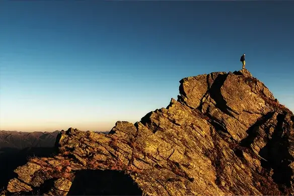 business person standing on top of summit