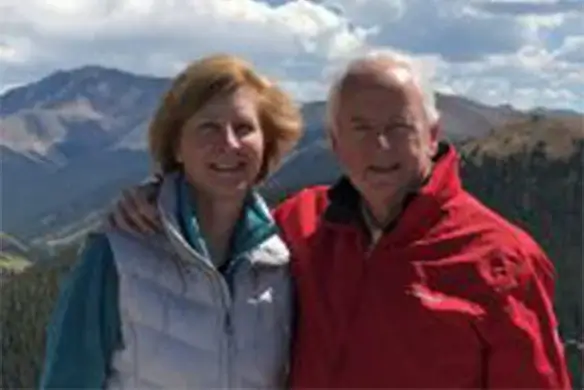 laura maver ward and her husband pose in front of a mountain