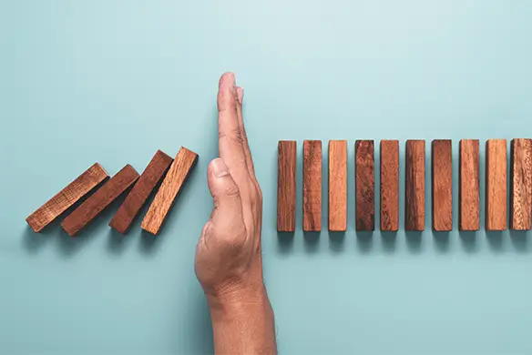 hand stopping falling blocks illustrating avoiding mistakes