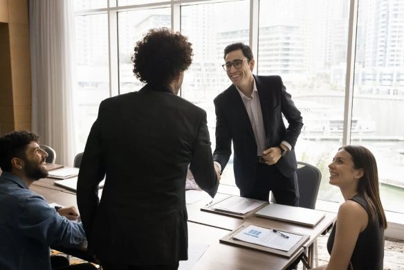 business professionals shake hands during behavioral health deal
